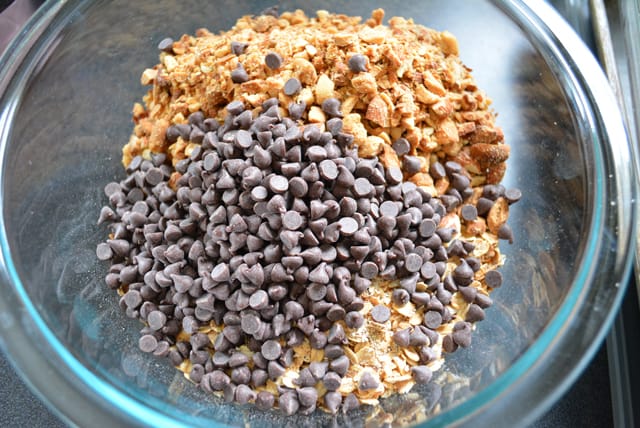 Chocolate chips, oats, and nuts in a glass bowl.