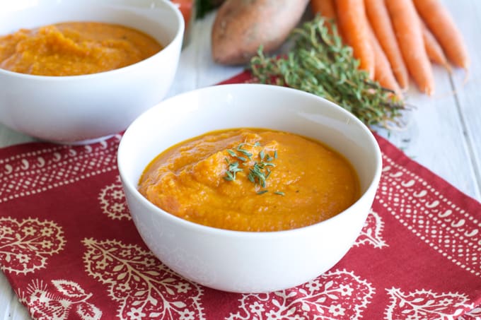 Roasted Carrot Sweet Potato Soup in a white bowl on top of a red napkin.