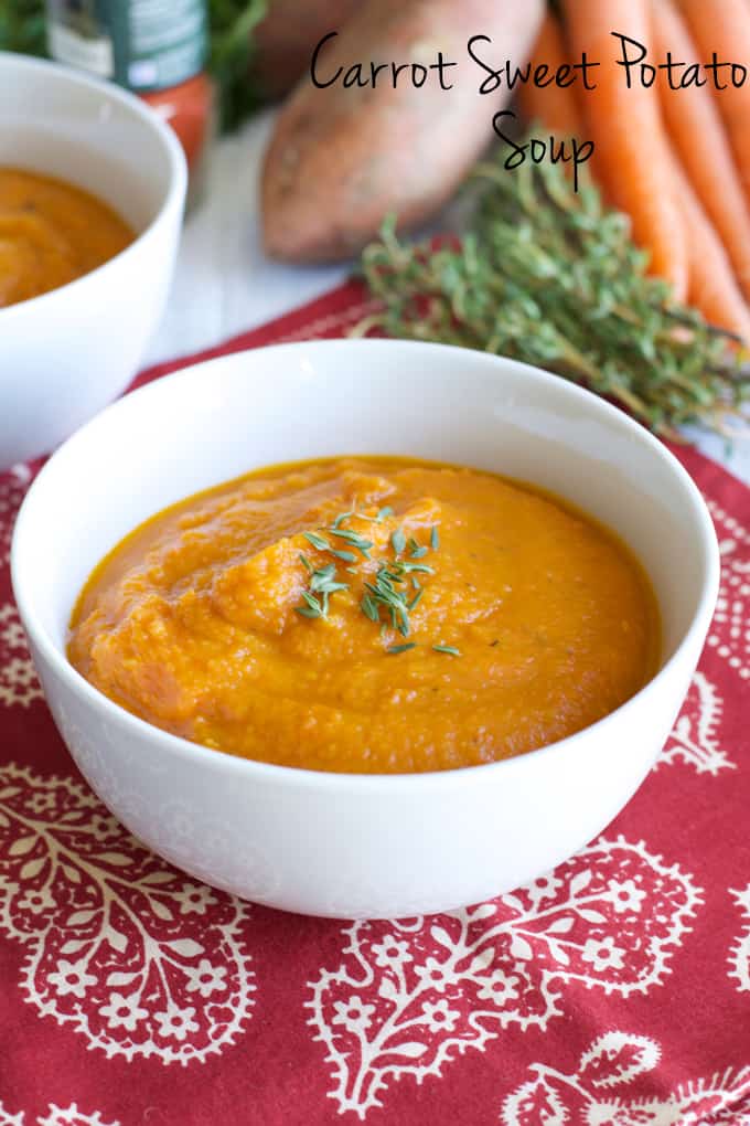 Soup made with carrot and sweet potatoes roasted and pureed in a white bowl.