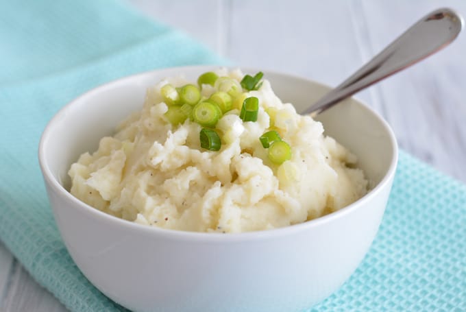 Homemade mashed potatoes in a white bowl.