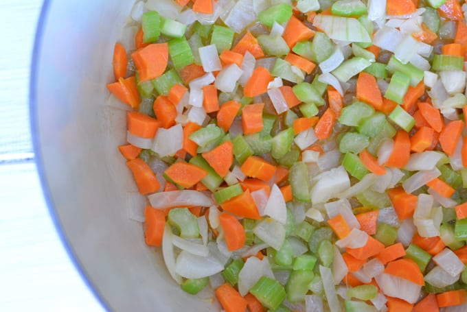 Diced carrots, onion, and celery cooked in a dutch oven.