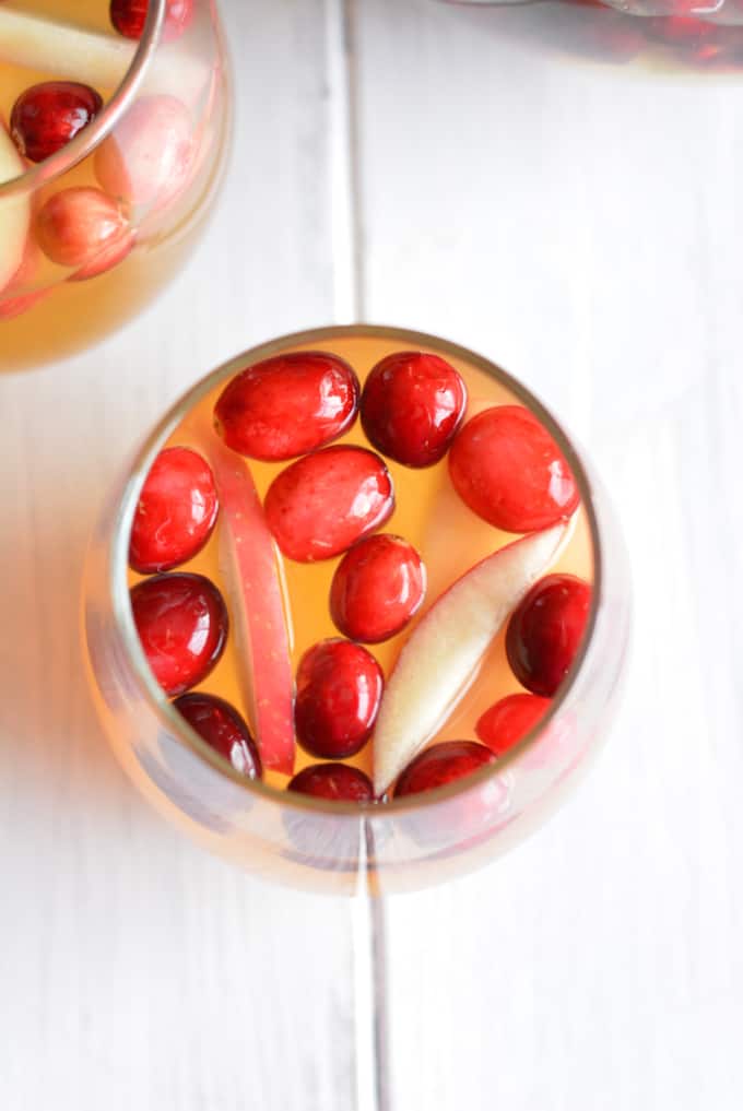 White sangria with apple slices and cranberries.