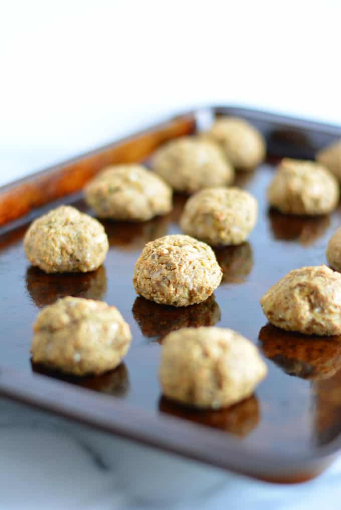 Vegetable balls made with eggplant on a baking sheet.