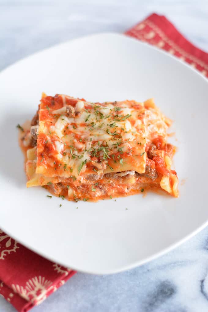 Lasagna with ground beef on a white plate.