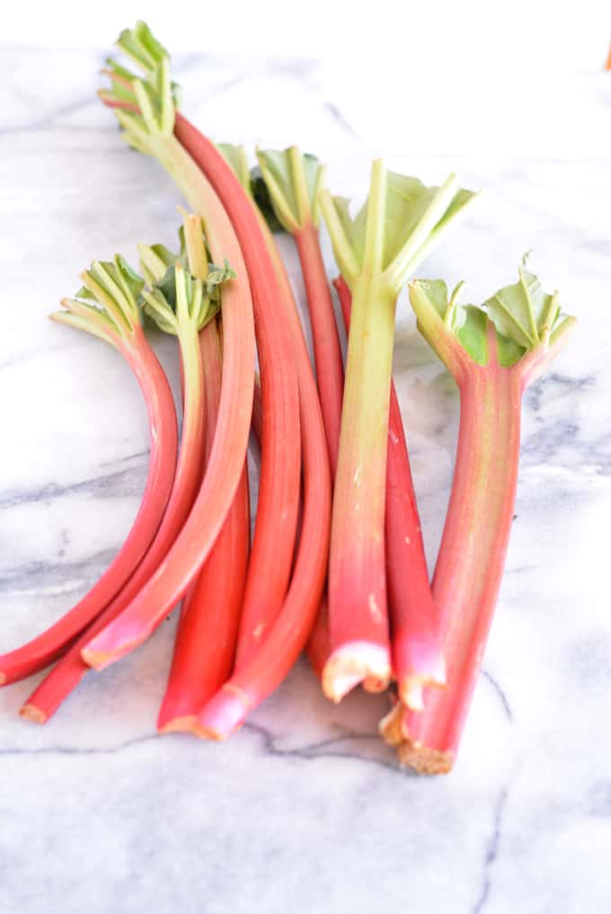 Stalks of Rhubarb laying on a white counter.