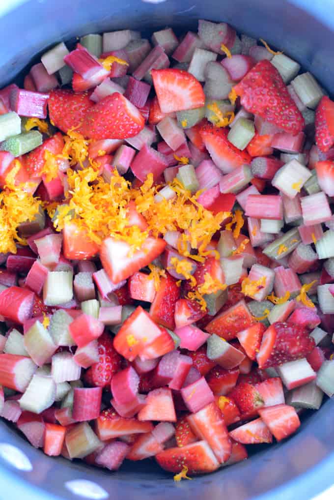 Rhubarb and strawberries diced in a pot with orange zest.