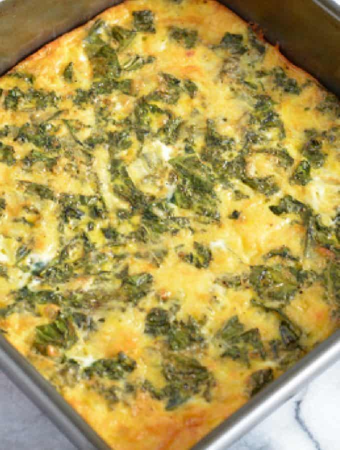 An egg frittata with kale with crust in a baking pan.