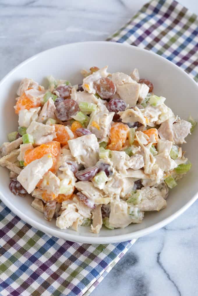 Chicken salad made with mandarin oranges and grapes in a white bowl.