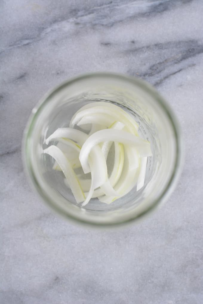 Onion slices inside a mason jar.