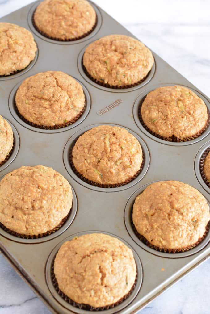 Baked zucchini muffins in a muffin baking pan.