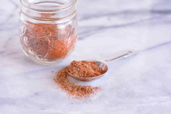 Homemade fajita seasoning in a jar and in a measuring spoon.