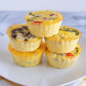 Egg muffins stacked on a white plate.